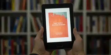 Hands holding a sleek e-reader displaying a colorful digital book cover, symbolizing the best e-reader discounts available in early 2025.
